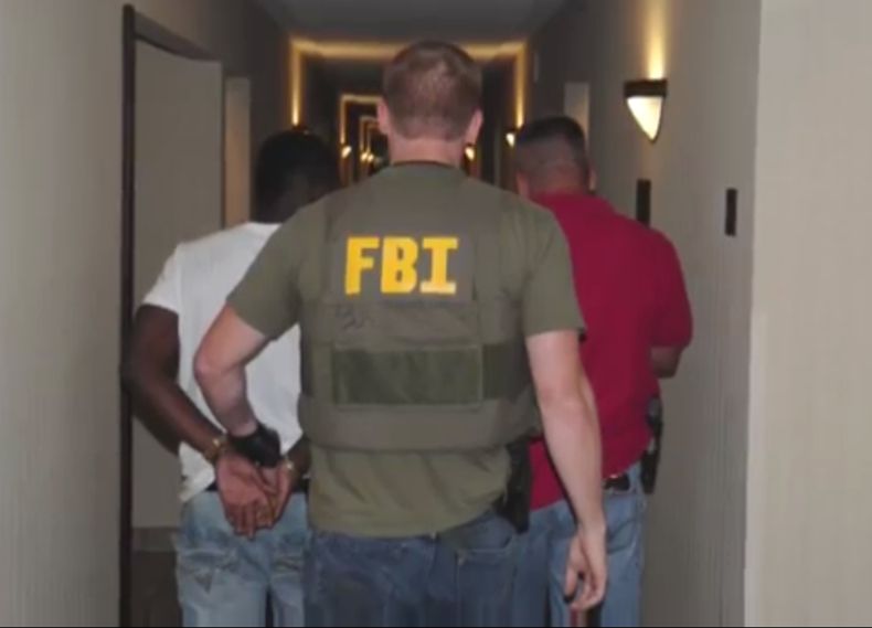En esta foto de junio de 2014 provista por el FBI, agentes allanan un hotel en Jackson, Mississippi. Cuando los agentes policiales y del FBI lanzaron una campa&ntilde;a el mes pasado para rescatar a ni&ntilde;os del tr&aacute;fico sexual, hallaron a menor