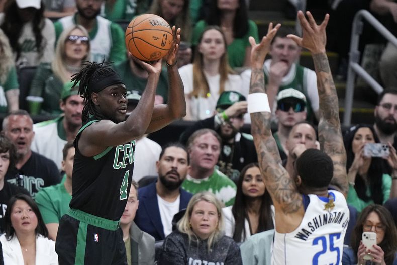 El base de los Celtics de Boston, Jrue Holiday realiza un tiro sobre el escolta de los Mavericks de Dallas, P.J. Washington (25) durante la primera mitad del Juego 2 de las Finales de la NBA, el domingo 9 de junio de 2024, en Boston. (AP Foto/Steven Senne)