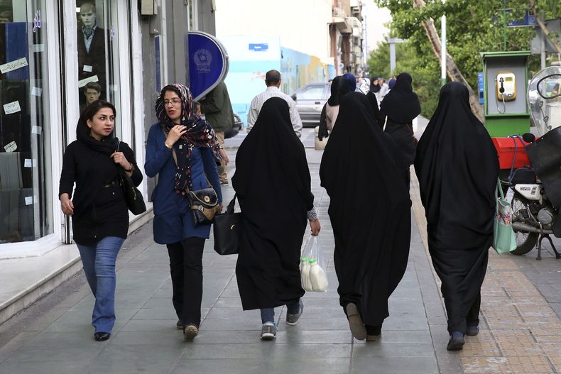 ARCHIVO - Mujeres iraníes caminan por una vereda en el centro de Teherán, Irán, el martes 26 de abril de 2016. Las autoridades iraníes anuncian una nueva campaña para obligar a las mujeres a llevar el pañuelo islámico en la cabeza, y la policía de la moral regresa a las calles 10 meses después de que la muerte de una mujer a la que habían detenido desencadenara protestas en todo el país. (AP Foto/Vahid Salemi, Archivo)