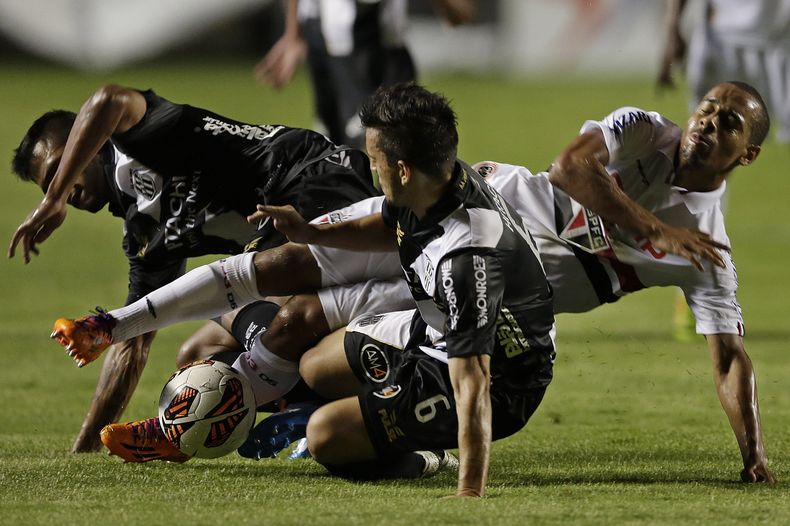Ademilson, del Sao Paulo, cae al disputar el bal&oacute;n con Uendel (primer plano) y Fernando Bob, del Ponte Preta, en un duelo entre clubes brasile&ntilde;os por la ida de las semifinales en la Copa Sudamericana, el mi&eacute;rcoles 20 de noviembre de 2