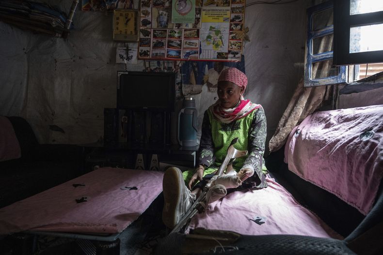 Melissa Amuli, una de las muchas personas heridas por los combates en la región, se sienta en su casa en Goma, este de la República Democrática del Congo, el viernes 29 de agosto de 2025. (AP Foto/Moses Sawasawa)