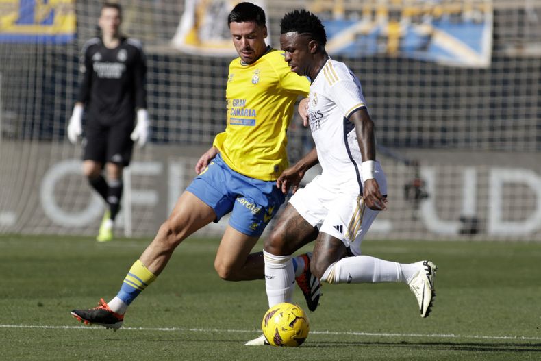 Vinicius Junior del Real Madrid avanza con el balón mientras lo defiende Javi Muñoz de Las Palmas en la liga española el sábado 27 de enero del 2024. (AP Foto/Gerardo Ojeda)