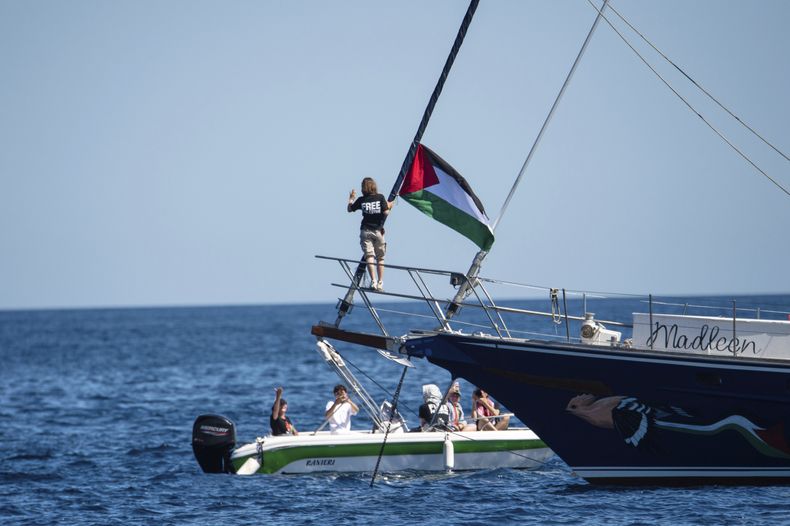 La activista Greta Thunberg cerca de una bandera palestina tras abordar el barco Madleen que iba rumbo a Gaza para entregar ayuda humanitaria, en Catania, en Sicilia, Italia, el 1 de junio del 2025. (AP foto/Salvatore Cavalli)