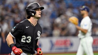 Andrew Benintendi (23), de los Medias Blancas de Chicago, corre las bases después de batear un jonrón frente a Nick Martinez, al fondo, lanzador de los Rays de Tampa Bay, durante la segunda entrada del juego de béisbol de Grandes Ligas del viernes 31 de julio de 2026, en San Petersburgo, Florida. (AP Foto/Jason Behnken)