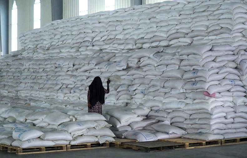 ARCHIVO - Un trabajador camina junto a una pila de sacos de comida con destino a las regiones de Tigray y de Afar, en un almacén del Programa Mundial de Alimentos en Semera, la capital de la región de Afar, en Etiopía, el 21 de febrero de 2022. (AP Foto, Archivo)