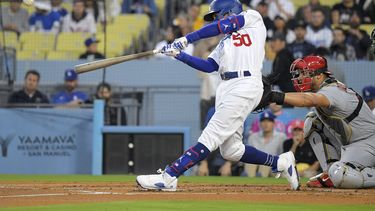 Mookie Betts (izquierda), de los Dodgers de Los Ángeles, conecta un jonrón solitario ante el catcher de los Cardenales de San Luis, Willson Contreras, en el primer inning del juego de la MLB que enfrentó a ambis equipos, el 28 de abril de 2023, en Los Ángeles. (AP Foto/Mark J. Terrill)