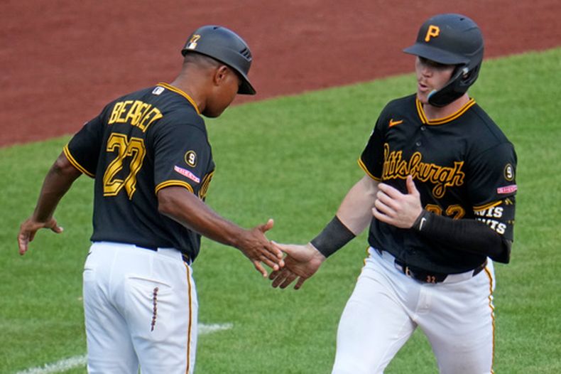 Henry Davis (derecha) de los Piratas de Pittsburgh saluda al coach de tercera base Tony Beasley tras batear un jonrón ante los Cerveceros de Milwaukee, el jueves 17 de septiembre de 2026. (AP Foto/Gene J. Puskar)