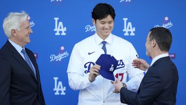 Shohei Ohtani recibe una gorra de manos de Andrew Friedman, presidente de operaciones deportivas de los Dodgers de Los Ángeles, el jueves 14 de diciembre de 2023 (AP Foto/Ashley Landis)