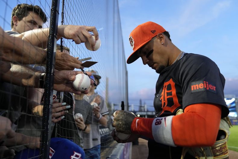 Javier Báez de los Tigres de Detroit firmando autógrafos previo a un juego de pretemporada contra los Yanquis de Nueva York, el 7 de marzo de 2024, en Tampa, Florida. (AP Foto/Charlie Neibergall)