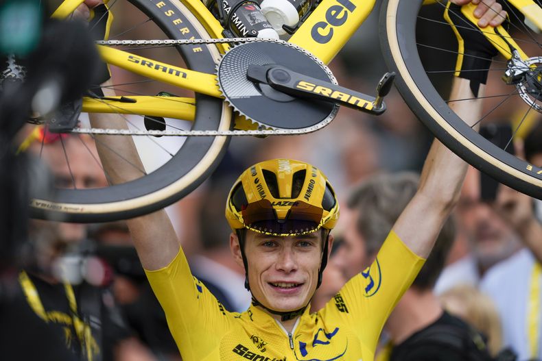 El danés Jonas Vingegaard, campeón del Tour de Francia, laza su bicicleta al final de la 21ra etapa, el domingo 23 de julio de 2023. (AP Foto/Thibault Camus)