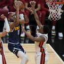 El alero de los Nuggets de Denver Bruce Brown avanza hacia la canasta mientras lo defienden el alero Caleb Martin y el base Kyle Lowry del Heat de Miami en el juego 4 de las Finales de la NBA el viernes 9 de junio del 2023. (AP Foto/Lynne Sladky)