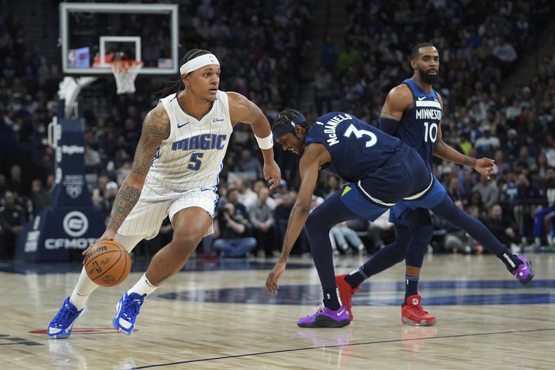 Paolo Banchero (5), del Magic de Orlando, se enfila rumbo a la canasta después de dejar atrás a Jaden McDaniels (3), de los Timberwolves de Minnesota, durante la segunda mitad del juego de baloncesto de la NBA, el viernes 2 de febrero de 2024. en Minneapolis. (AP Foto/Abbie Parr)