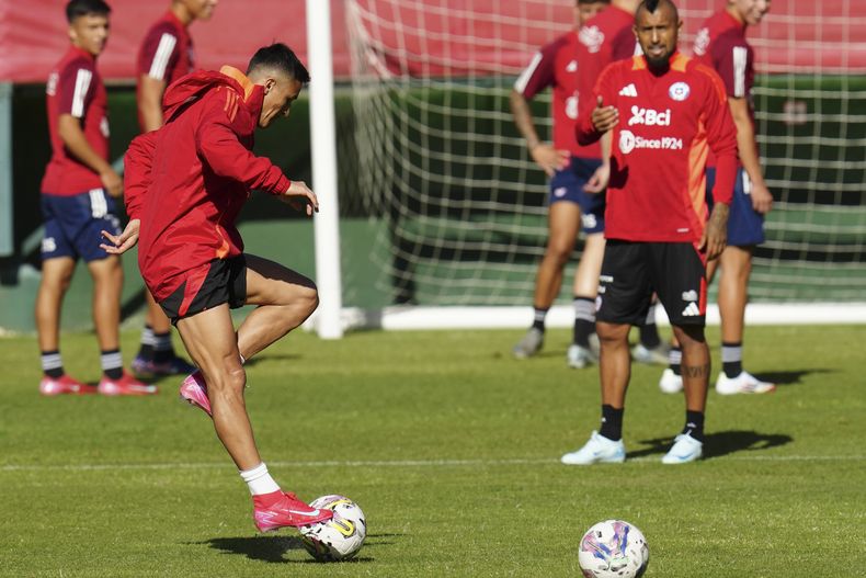El atacante Alexis Sánchez (primer plano) y su compañero Arturo Vidal durante un entrenamiento de la selección de Chile, el martes 18 de marzo de 2025, en Santiago. (AP Foto/Esteban Félix)