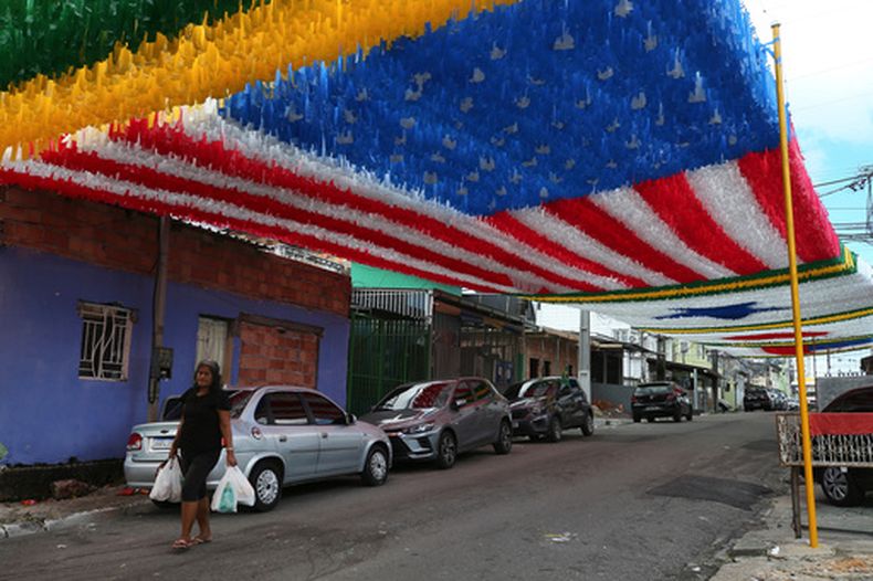 ARCHIVO - Una mujer camina debajo de la decoración mundialista en Manaos, Brasil, el 17 de mayo de 2026 (AP Foto/Edmar Barros)