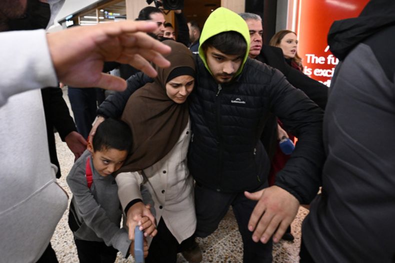 Un grupo de partidarios rodean a una mujer con supuestos vínculos con el grupo extremista Estado Islámico a su llegada, con un niño, al aeropuerto de Melbourne, en Melbourne, Australia, el 7 de mayo de 2026. (Joel Carrett/AAP Image vía AP)