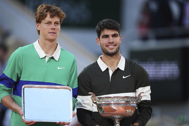 El ganador, el español Carlos Alcaraz, derecha, y el segundo clasificado, el italiano Jannik Sinner, posan con los trofeos tras el partido final del torneo de tenis French Open en el estadio Roland-Garros de París el domingo 8 de junio de 2025. (AP Foto/Lindsey Wasson, Archivo)