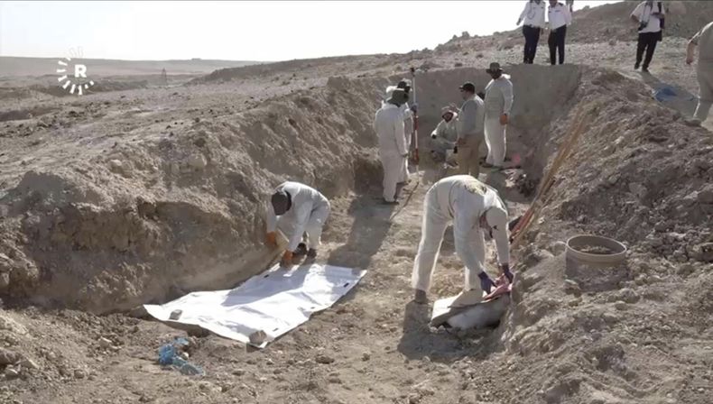 En esta imagen tomada de un video proporcionado por Rudaw TV, los trabajadores desentierran restos humanos en el sitio de Khasfa, cerca de la ciudad de Mosul, en el norte de Irak, donde las autoridades han comenzado a excavar una fosa común que se cree que contiene miles de víctimas del Estado Islámico, en Mosul, Irak, el domingo 17 de agosto de 2025. (Rudaw TV vía AP)