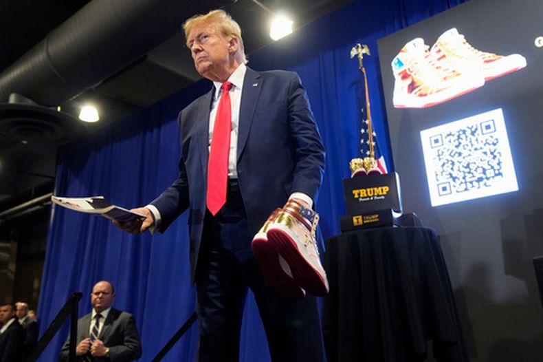 El presidente estadounidense Donald Trump presenta una revista Playboy y zapatillas doradas Trump en Sneaker Con Philadelphia, un evento popular entre coleccionistas de zapatillas, en Filadelfia, el sábado 17 de febrero de 2024. (Foto AP/Manuel Balce Ceneta, Archivo)