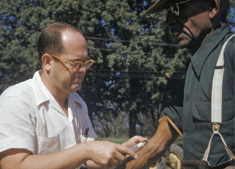 En esta foto de archivo de 1950 publicada por los Archivos Nacionales, un médico extrae sangre a un hombre afroestadounidense al que se incluyó en un estudio sobre la sífilis en Tuskegee, Alabama. (National Archives via AP)