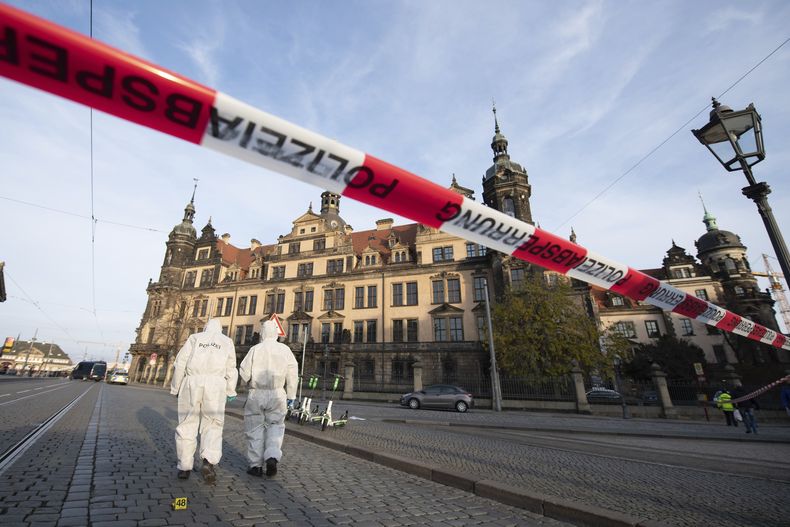 ARCHIVO - Investigadores de la policía caminan ante el Residenzschloss, o Palacio residencial, que alberga el museo de la Bóveda Verde en Dresde, Alemania, el 25 de noviembre de 2019. Una corte alemana condena a cinco hombres por el robo de joyas del siglo XVIII valoradas en más de 100 millones de euros de un museo en Dresde en 2019. En enero se alcanzó un acuerdo entre la defensa, la fiscalía y la corte tras la devolución de la mayoría de las joyas. (Sebastian Kahnert/dpa via AP, Archivo)