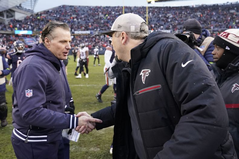 Matt Eberflus, izquierda, head coach de los Bears de Chicago saluda a Arthur Smith, derecha, entrenador de los Falcons de Atlanta, después de un partido de la NFL en Chicago, el domingo 31 de diciembre de 2023. (AP Foto/Charles Rex Arbogast)