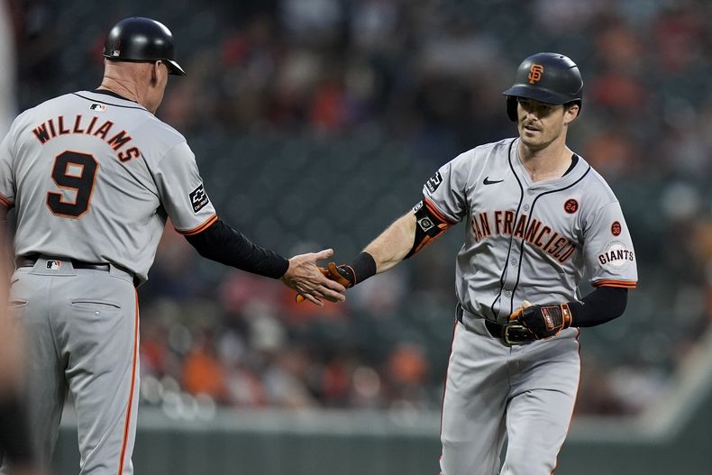 Mike Yastrzemski, de los Gigantes de San Francisco, festeja con el coach de la antesala Matt Williams luego de batear un jonrón ante los Orioles de Baltimore, el miércoles 18 de septiembre de 2024 (AP Foto/Stephanie Scarbrough)