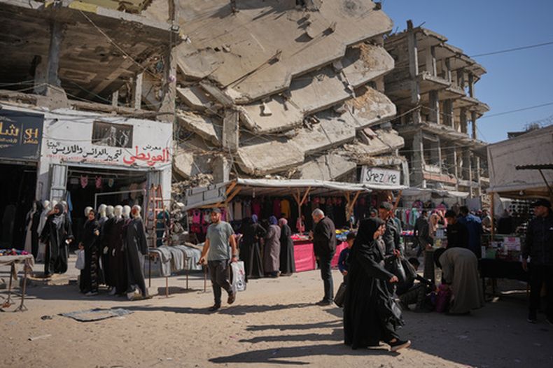 Varios palestinos compran en un mercado preparándose para la festividad islámica de Eid al-Fitr en Jan Yunis, en el sur de la Franja de Gaza, el martes 17 de marzo de 2026. (AP Foto/Abdel Kareem Hana)