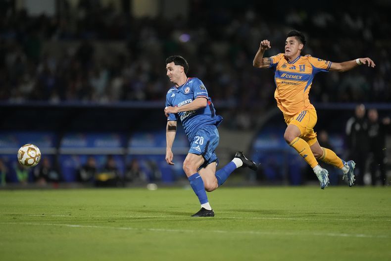 José Paradela, de Cruz Azul, persigue un balón frente a Antonio Carrera, de Tigres, en la ida de las semifinales de la Liga MX, el miércoles 3 de diciembre de 2025 en Ciudad de México (AP Foto/Eduardo Verdugo)