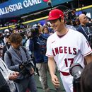 Shohei Ohtani jugador de Los Angelinos de Los Ángeles de la Liga Americana sonríe mientras camina hacia los jardines luego de atender a los medios en Seattle. Lunes 10 de julio de 2023. (AP Foto/Lindsey Wasson)