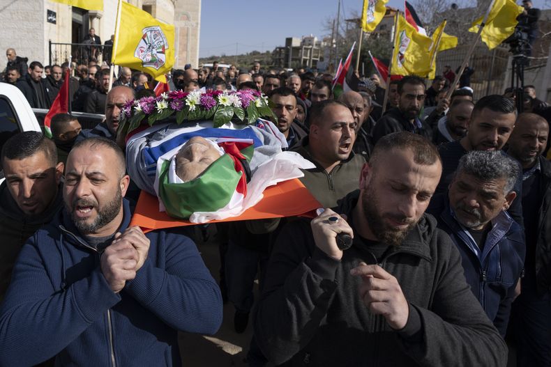 ARCHIVO - Dolientes cargan el cadáver de Omar Assad durante su funeral en la aldea cisjordana de Jiljiliya, al norte de Ramallah, el jueves 13 de enero de 2022. El palestino-estadounidense fue hallado muerto poco después de ser detenido por el batallón Netzah Yehuda en un puesto de control de Cisjordania. (AP Foto/Nasser Nasser, archivo)