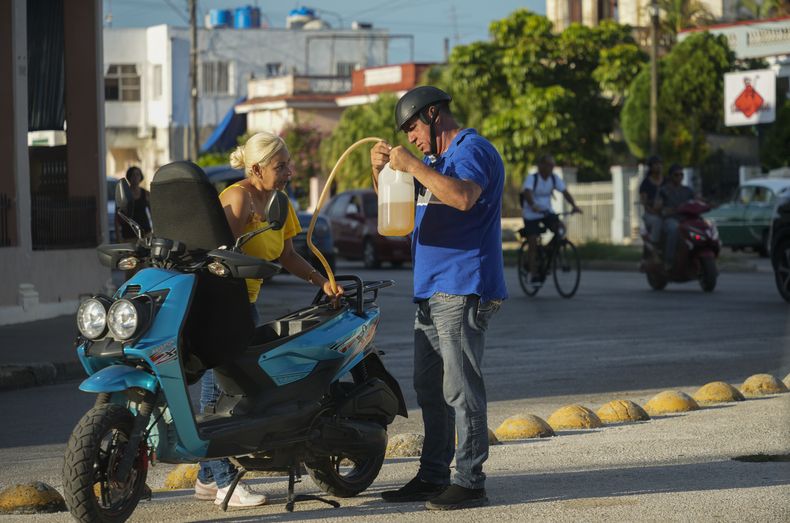 Un hombre llena su motocicleta con gasolina de un bidón de plástico en La Habana, Cuba, el martes 24 de septiembre de 2024. (Foto AP/Ramón Espinosa)