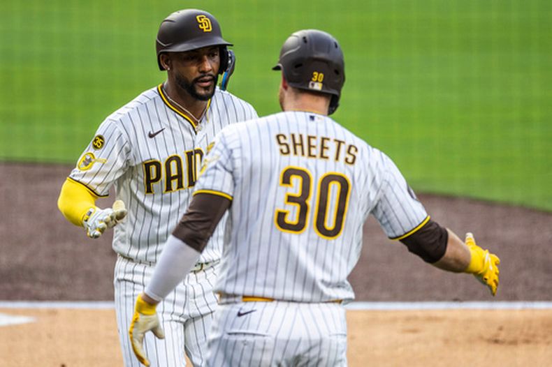 Miguel Andújar, izquierda, de los Padres de San Diego, celebra su cuadrangular de la primera entrada del juego de béisbol de Grandes Ligas con Gavin Sheets (30) en juego de béisbol de Grandes Ligas, el lunes 18 de mayo de 2026, en San Diego (AP Foto/Tony Ding)