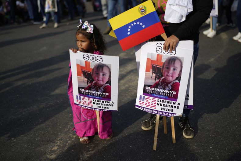 ARCHIVO – Un grupo de personas sostiene carteles con las imágenes de niños bajo custodia de Estados Unidos cuyos padres fueron deportados, en un mitin organizado por el gobierno en Caracas, Venezuela, el 10 de julio de 2025. (AP Foto/Ariana Cubillos, Archivo)