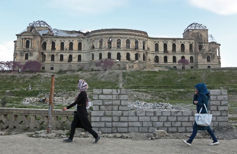 Muchachas afganas pasan frente al palacio del fallecido rey Amanul&aacute; Khan, el cual fue destruido durante la guerra civil a inicios de la d&eacute;cada de 1990, el domingo 27 de abril de 2014, en Kabul, Afganist&aacute;n. (Foto AP/Rahmat Gul)