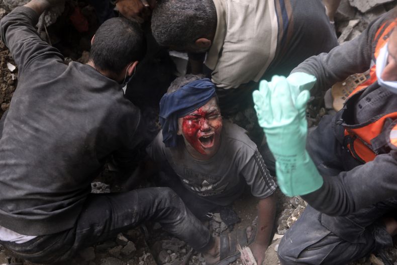 Un niño palestino herido llora mientras los rescatistas tratan de sacarlo de entre los escombros de un edificio destruido luego de un ataque aéreo israelí sobre el campo de refugiados de Bureij, en la Franja de Gaza, el 2 de noviembre de 2023. (AP Foto/Mohammed Dahman)