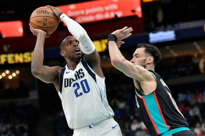 Khris Middleton, de los Mavericks de Dallas, dispara frente a Tyler Burton, de los Grizzlies de Memphis, el jueves 12 de marzo de 2026 (AP Foto/Brandon Dill)