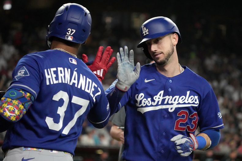 Kyle Tucker, de los Dodgers de Los Ángeles, celebra con Teoscar Hernández (37) tras conectar un cuadrangular solitario contra los Diamondbacks de Arizona en la octava entrada de un partido de béisbol, el sábado 8 de agosto de 2026, en Phoenix. (Foto AP/Rick Scuteri)