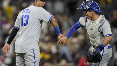 El venezolano Salvador Pérez, bateador designado de los Reales de Kansas City, festeja con su compatriota Freddy Fermín, tras el triunfo sobre los Padres de San Diego, el martes 16 de mayo de 2023 (AP Foto/Gregory Bull)