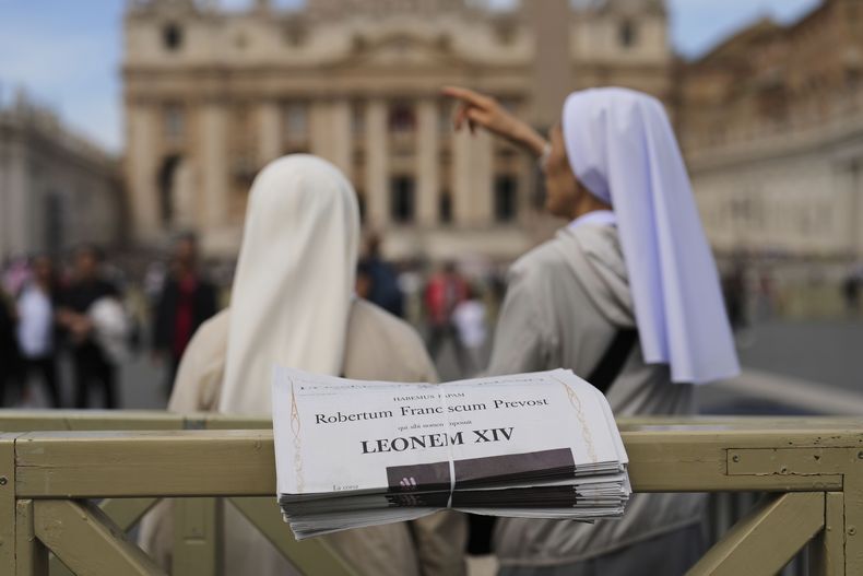 ARCHIVO – Dos monjas junto a ejemplares del diario LOsservatore Romano con encabezados en latín del papa León XIV en el Vaticano, el viernes 9 de mayo de 2025, un día después de su elección como primer pontífice norteamericano. (AP Foto/Francisco Seco, Archivo)