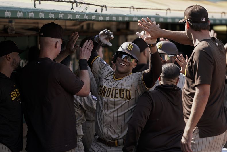 El dominicano Juan Soto de los Padres de San Diego celebra con sus compañeros tras pegar u grand slam en la octava entrada del juego ante los Atléticos de Oakland el domingo 17 de septiembre del 2023. (AP Foto/Godofredo A. Vásquez)