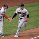 Pavin Smith, de los Diamondbacks de Arizona, recorre la antesala es felicitado por el coach Tony Perezchica, luego de batear un jonrón el sábado 20 de mayo de 2023, ante los Piratas de Pittsburgh (AP Foto/Gene J. Puskar)
