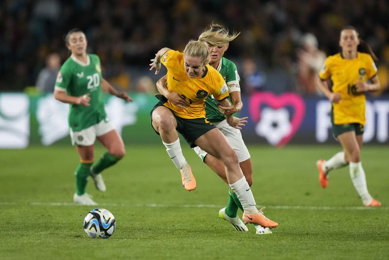 La australiana Ellie Carpenter (izquierda) disputa el balón con la irlandesa Katie McCabe en el Mundial femenino, el jueves 20 de julio de 2023, en Sídney, Australia. (AP Foto/Rick Rycroft)