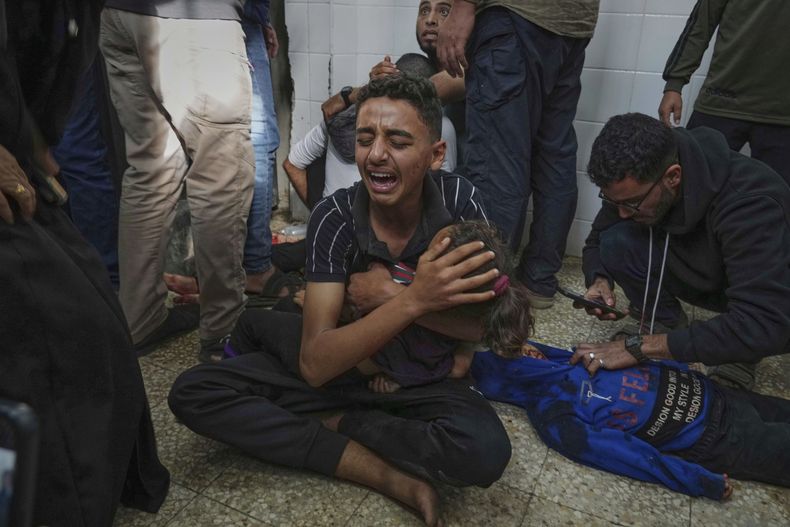 ARCHIVO - Mohammed Abed (centro) llora mientras sostiene el cuerpo de su hermana menor, Massa, de 4 años de edad, quien murió en un ataque aéreo israelí en la Franja de Gaza, en la morgue del Hospital Al Aqsa, en Deir al-Balah, Gaza, el domingo 27 de abril de 2025. (AP Foto/Abdel Kareem Hana, Archivo)
