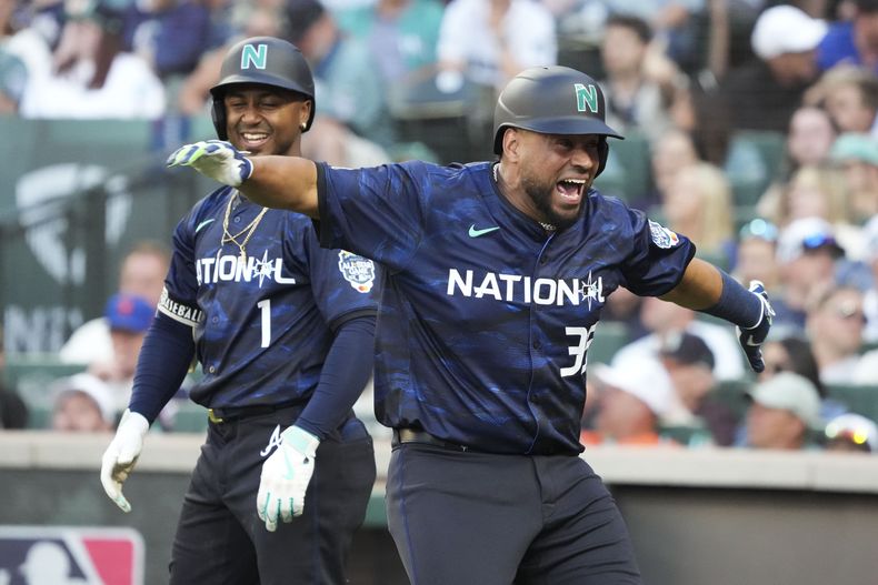 El venezolano Elías Díaz, de los Rockies de Colorado, festeja su jonrón de dos carreras con Ozzie Albies, de los Bravos de Atlanta, el martes 11 de julio de 2023 (AP Foto/Ted S. Warren)
