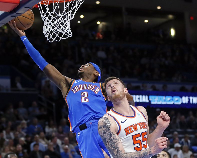 Shai Gilgeous-Alexander, base del Thunder de Oklahoma City, encesta detrás de Isaiah Hartenstein, pívot de los Knicks de Nueva York, en el encuentro del miércoles 27 de diciembre de 2023 (AP Foto/Nate Billings)