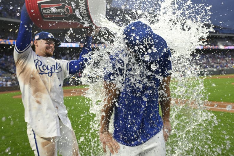 Bobby Witt Jr., de los Reales de Kansas City, arroja agua fría al abridor Brady Singer, tras la victoria sobre los Medias Blancas de Chicago, el sábado 20 de julio de 2024 (AP Foto/Reed Hoffmann)