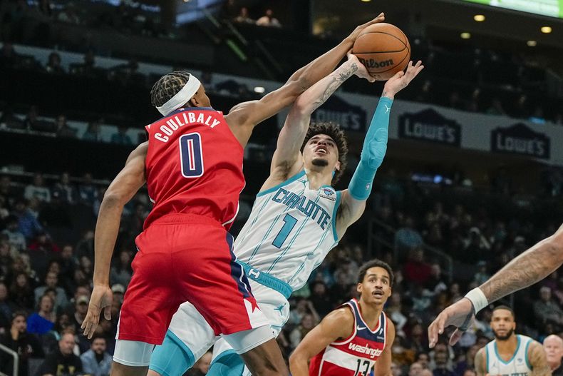 LaMelo Ball, de los Hornets de Charlotte, dispara con la marca encima de Bilal Coulibaly, de los Wizards de Wahington, durante la segunda mitad del juego de baloncesto de la NBA, el miércoles 22 de noviembre de 2023, en Charlotte, Carolina del Norte. Los Hornets ganaron 117-114. (AP Foto/Chris Carlson)