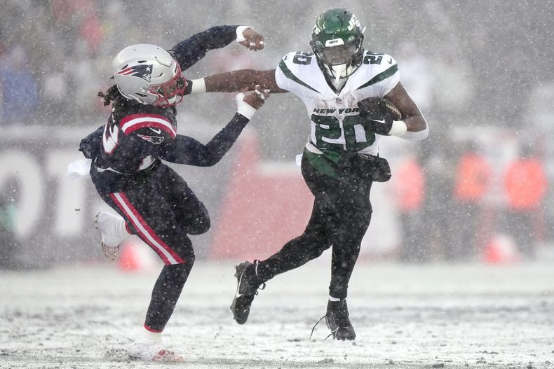 El corredor de los Jets de Nueva York Breece Hall empuja al safety de los Patriots de Nueva Inglaterra Kyle Dugger en el encuentro del domingo 7 de enero del 2024. (AP Foto/Steven Senne)