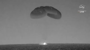En esta imagen tomada de un video divulgado por la NASA, una cápsula de SpaceX --con paracaídas desplegados para disminuir su velocidad-- cae en el Océano Atlántico el lunes 4 de septiembre de 2023, frente a la costa de Florida. (NASA vía AP)