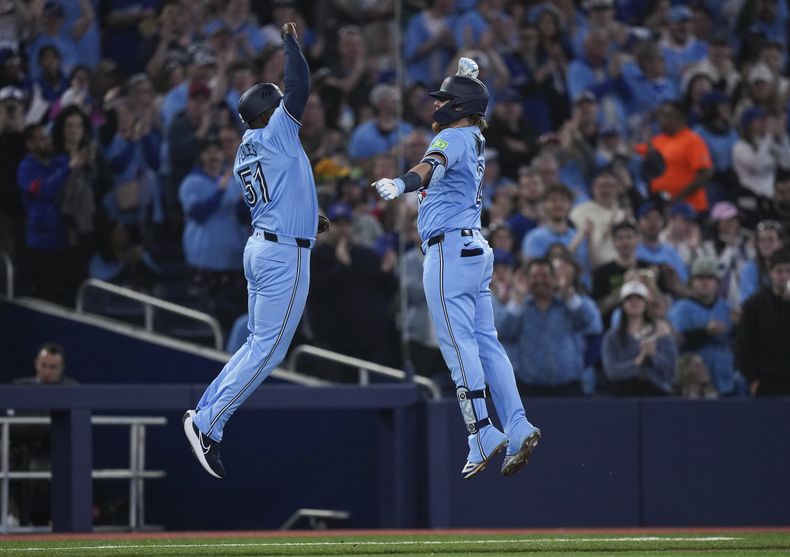 Justin Turner, derecha, bateador designado de los Azulejos de Toronro, celebra después de batear un jonrón solitario con el coach de tercera, Carlos Febles (51), durante el partido de béisbol en contra de los Reales de Kansas City en la tercera entrada, el lunes 29 de abril de 2024. (Nathan Denette/The Canadian Press vía AP)